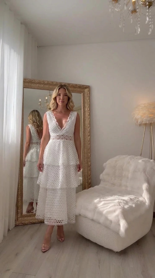 Front full-length view of woman wearing white sleeveless tiered lace midi dress with V-neck