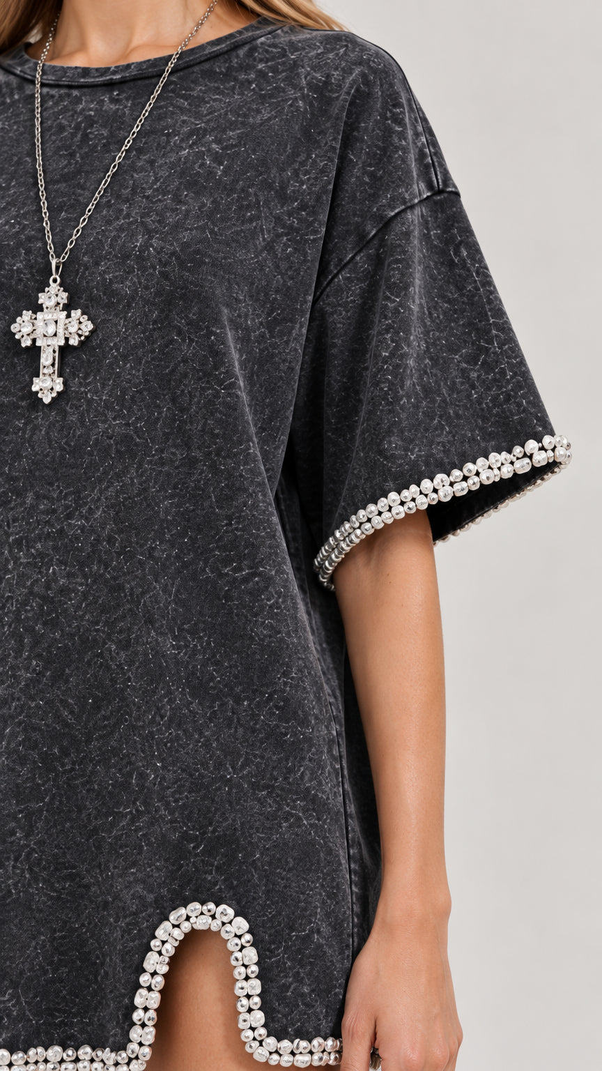 Close-up detail of rhinestone bead trimming on sleeve cuff and notched hem