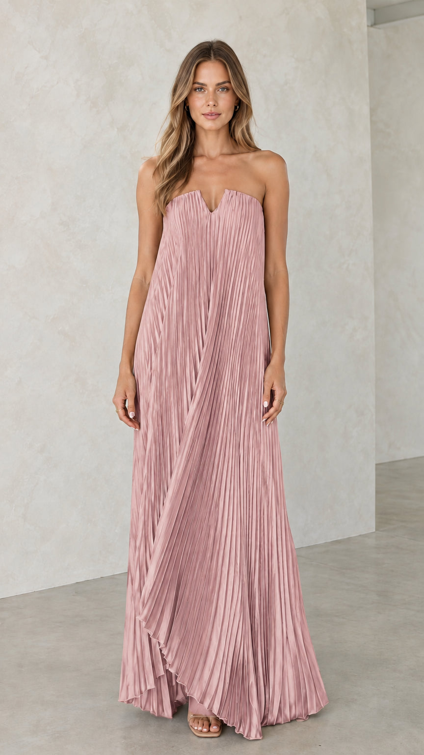 Model wearing dusty pink strapless pleated maxi dress