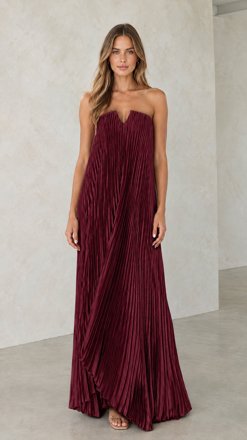 Model wearing burgundy strapless pleated maxi dress